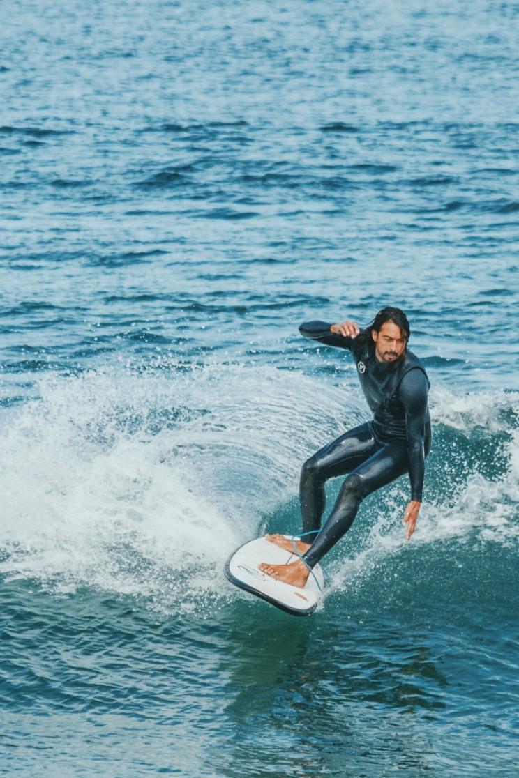 Hombre surfeando en tabla de surf hibrida